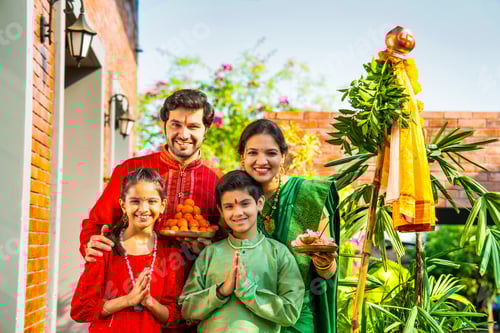 Preview: Happy Indian family in ethnic attire performing Gudi Padwa puja, a Hindu New Year celebration