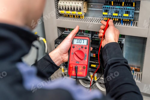 Preview: Worker measuring and repairing an electrical system panel
