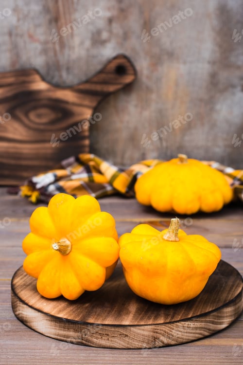 Preview: Three fresh bush pumpkin on a cutting board on wooden background