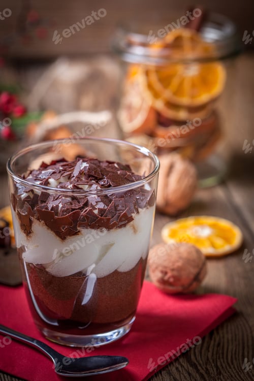Preview: Layered dessert in a glass on a wooden table.