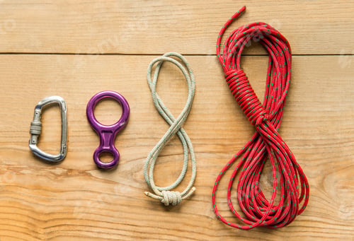 Preview: climbing equipment: rope, eight, carbine on wooden background, top view