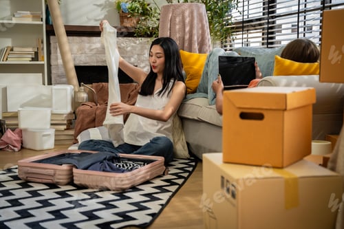 Preview: Two women are sitting on a couch, one of them holding a white shirt