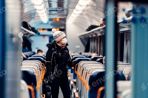 Preview: young woman with a face mask in a train at the time of the coronavirus. covid-19