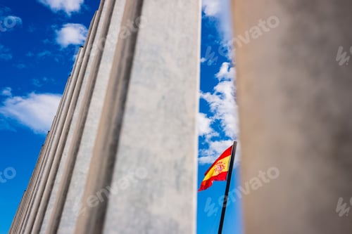 Preview: Spanish flag waving view between the bars of a border, concept of Spanish patriotism.