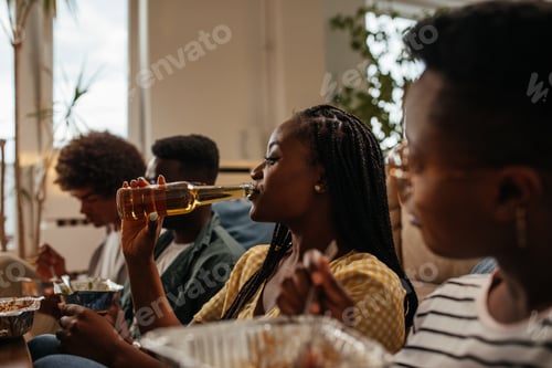 Preview: Group of friends eating takeout food and drinking beers