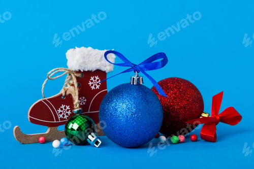Preview: Christmas ball with skates on colored background. decoration bauble with ribbon bow with copy space
