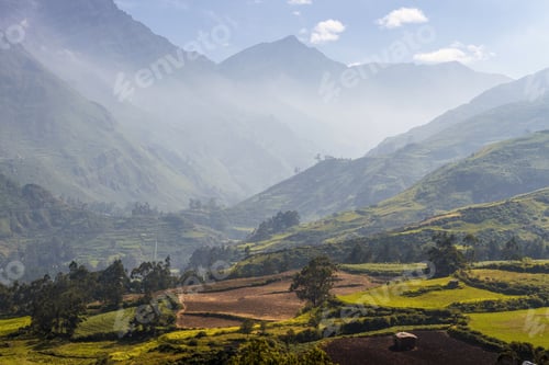 Preview: Horizontal shot of a beautiful green field and mountains during daylight
