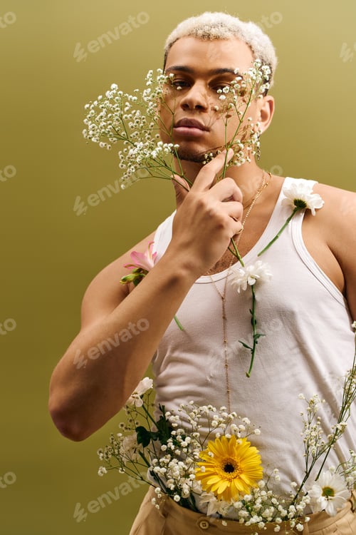 Preview: Young African American man showcases trendy style in studio with vibrant flowers