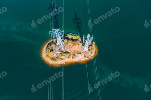 Preview: Aerial drone view of High voltage post or High voltage tower in deep blue water lake or river.