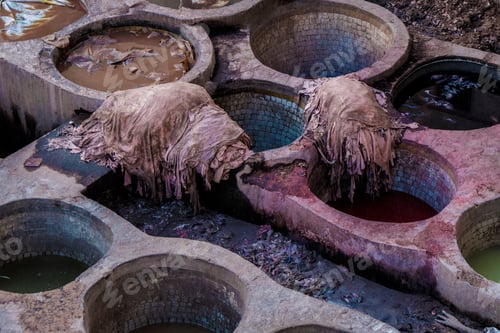 Preview: Heaps of dirty textile near containers with colorant liquid