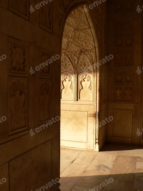 Preview: Vertical shot of sunlight coming through a hallway in the Agra Fort with carvings on the wall