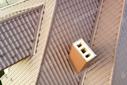 Preview: Aerial view of house roof structure covered with brown metal tile sheets.
