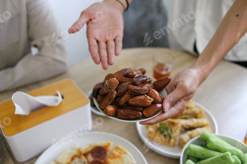 Preview: Close up of Muslim Man Offering a Plate of Dates Fruit for Break Fasting on Holy Ramadan Month