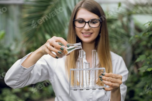 Preview: Female Scientist Pouring Liquid into Test Tubes