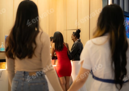 Preview: Close-up of a couple holding hands in a box office waiting to buy movie tickets