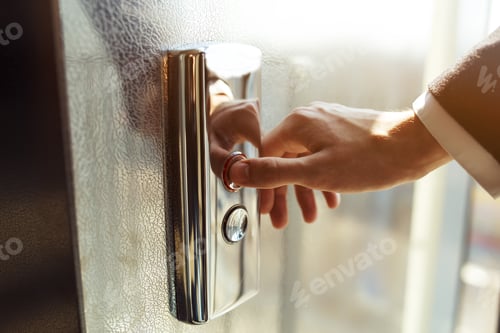 Preview: Man pressing elevator button. finger presses the elevator button. Red button. sunset light.