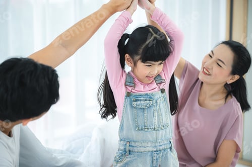 Preview: happy love family lifestyle with Asian father and mother and child daughter at home together