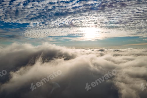 Preview: Aerial view from above of white puffy clouds in bright sunny day