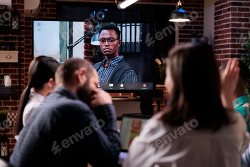 Preview: Woman raising hand to ask a question while discussing with remote manager during online video call