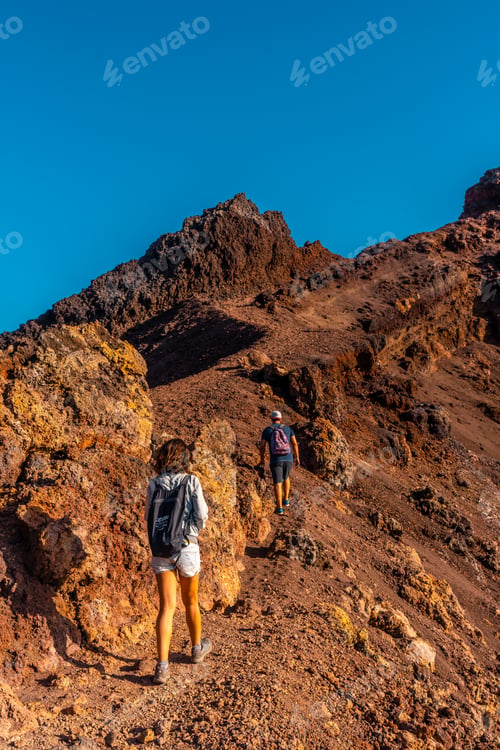 Preview: A young woman looking at the crater of the Teneguia volcano on the route
