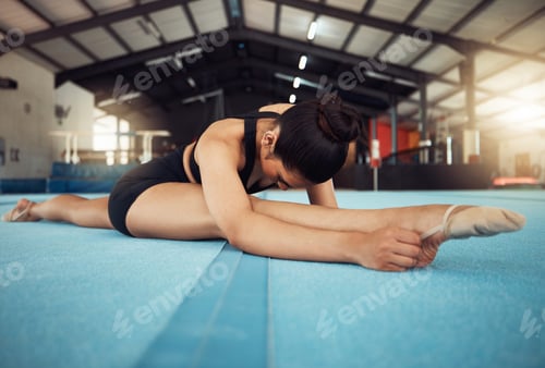 Preview: Sports woman stretching on the floor in yoga splits in a gym. Young fitness girl or athlete legs in