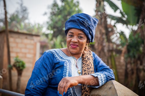 Preview: Attractive and smiling 50 year old African woman dressed in a traditional African dress
