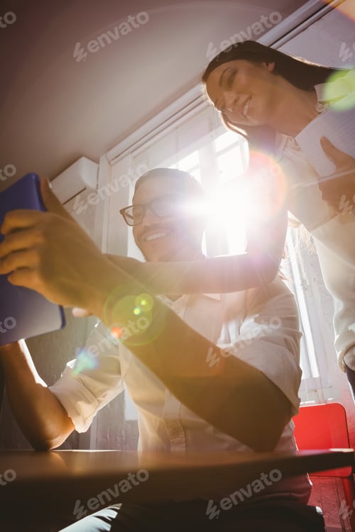 Preview: Two casual business people using digital tablet