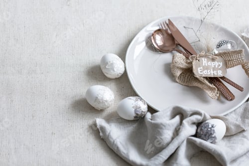 Preview: Festive Easter table setting with decor details on white table.
