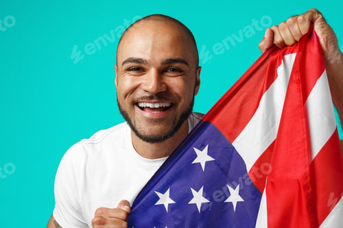 Preview: Portrait of young dark-skinned man proudly holding USA flag
