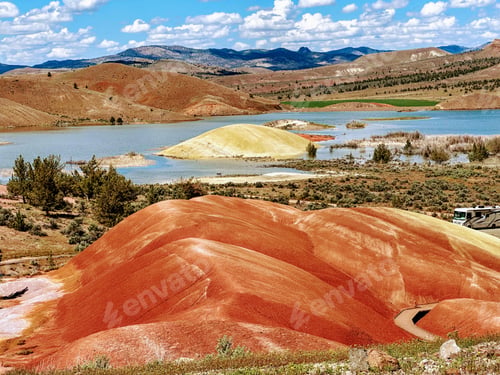 Preview: some very colorful hills near water and rocks near water hole