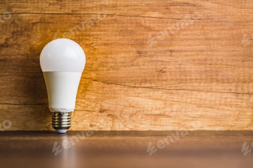 Preview: Energy saving light bulb on wooden table. Led Lightbulb.