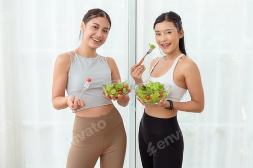 Preview: Two Young Asian Women Enjoying Healthy Salads and Smiling in a Bright, Modern Kitchen