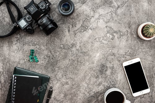 Preview: Top view a plaster background with a photocamera, smartphone and
stationery