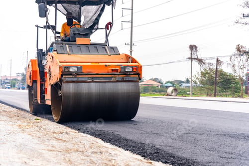 Preview: Machines are crushing the asphalt after pouring to make a road for cars.