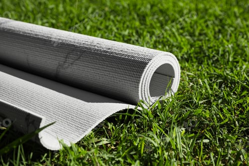Preview: Karemat or fitness mat on green grass outdoors, closeup