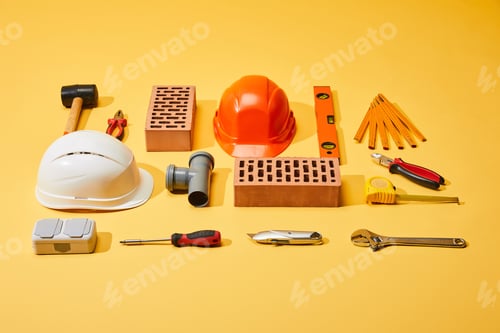 Preview: flat lay with bricks, helmets, industrial tools and measuring tape on yellow background