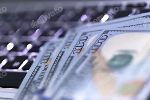 Preview: Money resting on a laptop keyboard during a tech-focused financial review session