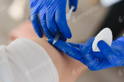 Preview: Female doctor making injecting using syringe to male patient in hospital.