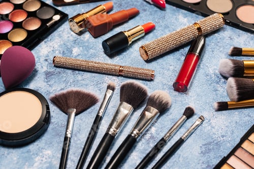 Preview: Various makeup products, brushes on blue background