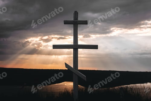 Preview: Cross In sunset light from dark clouds