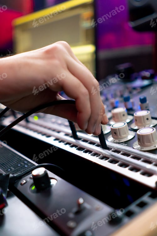 Preview: close up in dark recording studio the sound engineer works with the remote control and connects the