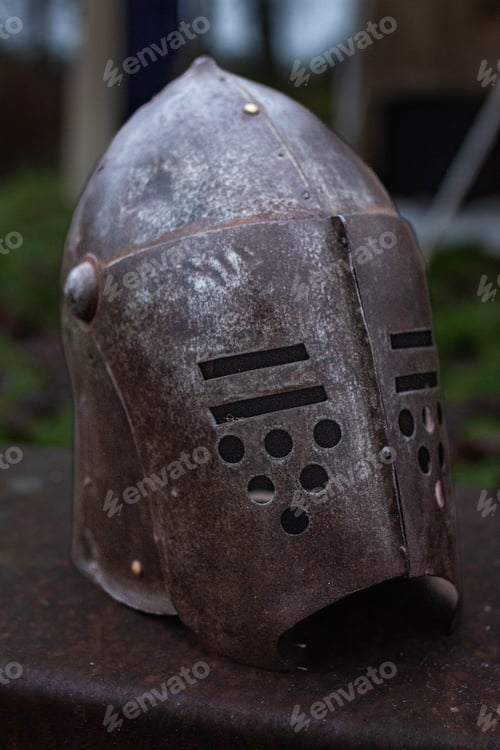 Preview: Silver medieval helmet sits atop a rustic table