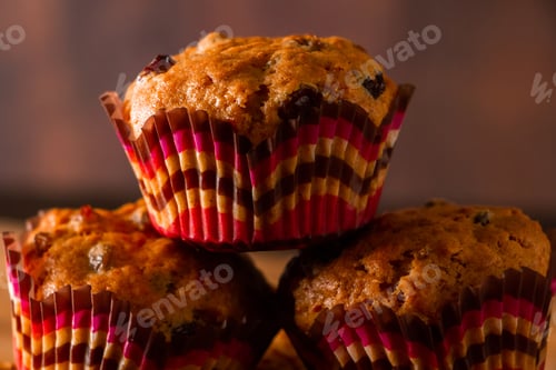 Preview: Freshly baked homemade muffins with raisins and carrots. Vegetarian pastries on a wooden background.