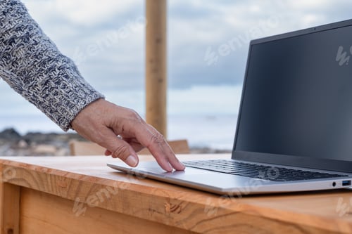Preview: Adult mature senior caucasian business woman hand touching laptop keyboard in outdoors
