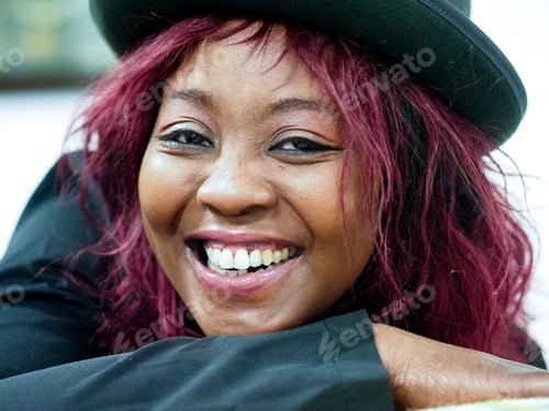 Preview: happy cheerful young african american woman red hair style wearing a black jacket
