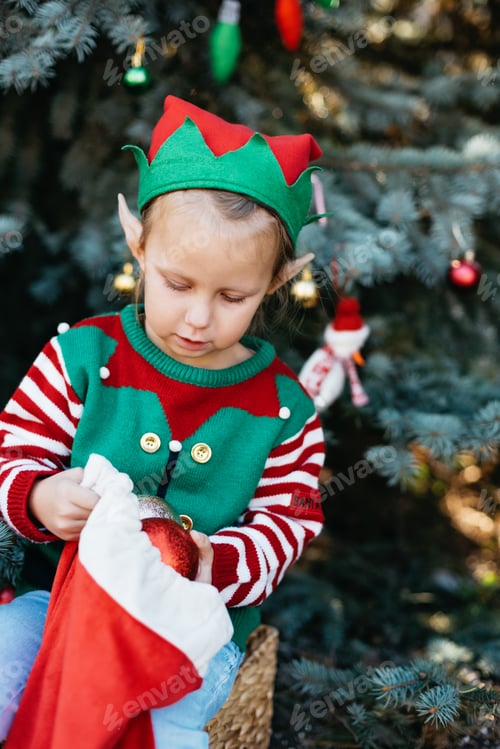 Preview: Child waiting for Christmas in wood. portrait of little girl decorating christmas tree.