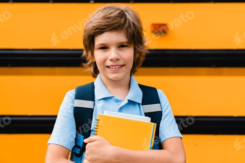 Preview: Small kid young pupil boy coming back to school after summer holidays waiting next to the school bus