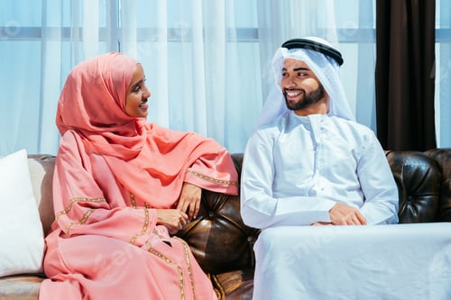 Preview: Happy middle eastern couple wearing traditional arab clothing at home
