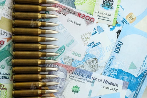 Preview: Nigerian naira currency money bills and rifle bullets. The concept of warfare and gun selling