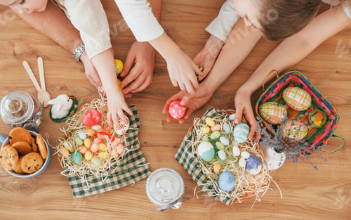 Preview: Top view of hands on the table. Happy family celebrating Easter holidays together